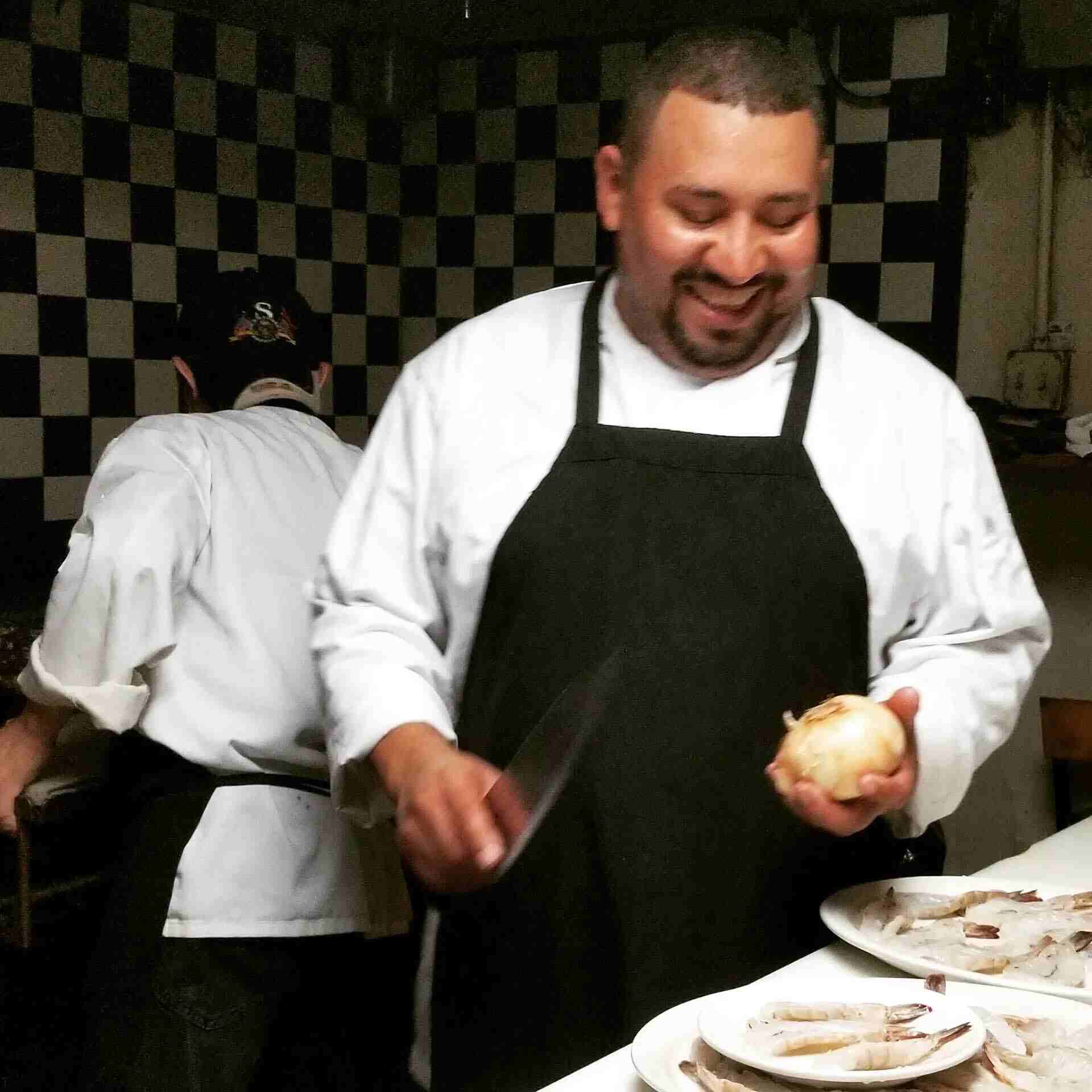 Chef Nelson Umana preparing dishes in the kitchen at El Puerto Restaurant